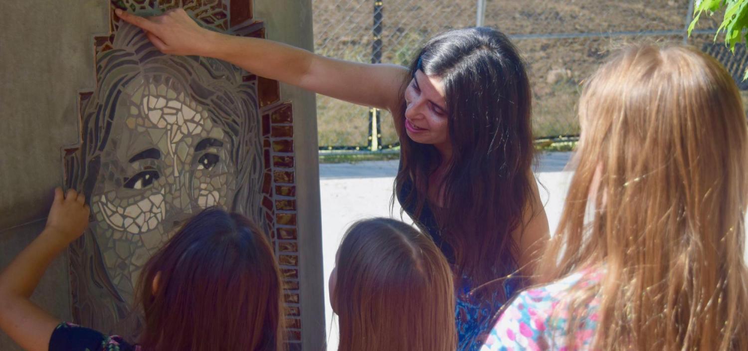 Jasmine Baetz talks to CU Science Discovery campers about one of the mosaic portraits.